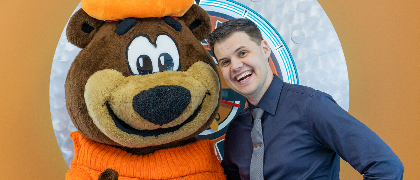 Photo of Brett Allan with Rooty the Great Root Bear.